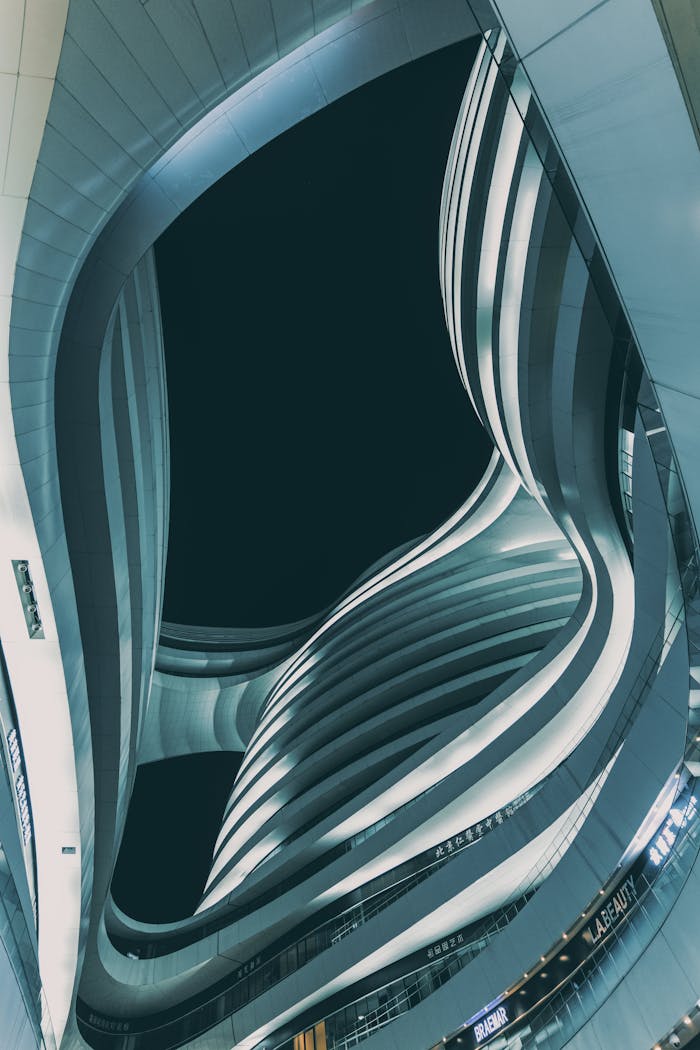 Low angle view of modern Milky Way Soho in Beijing at dusk. Futuristic curves and lines in dramatic urban setting.